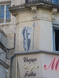 Street Art: PasteUp: Kleiner Indianer mit großer Federpracht an der Mauer von Montpellier